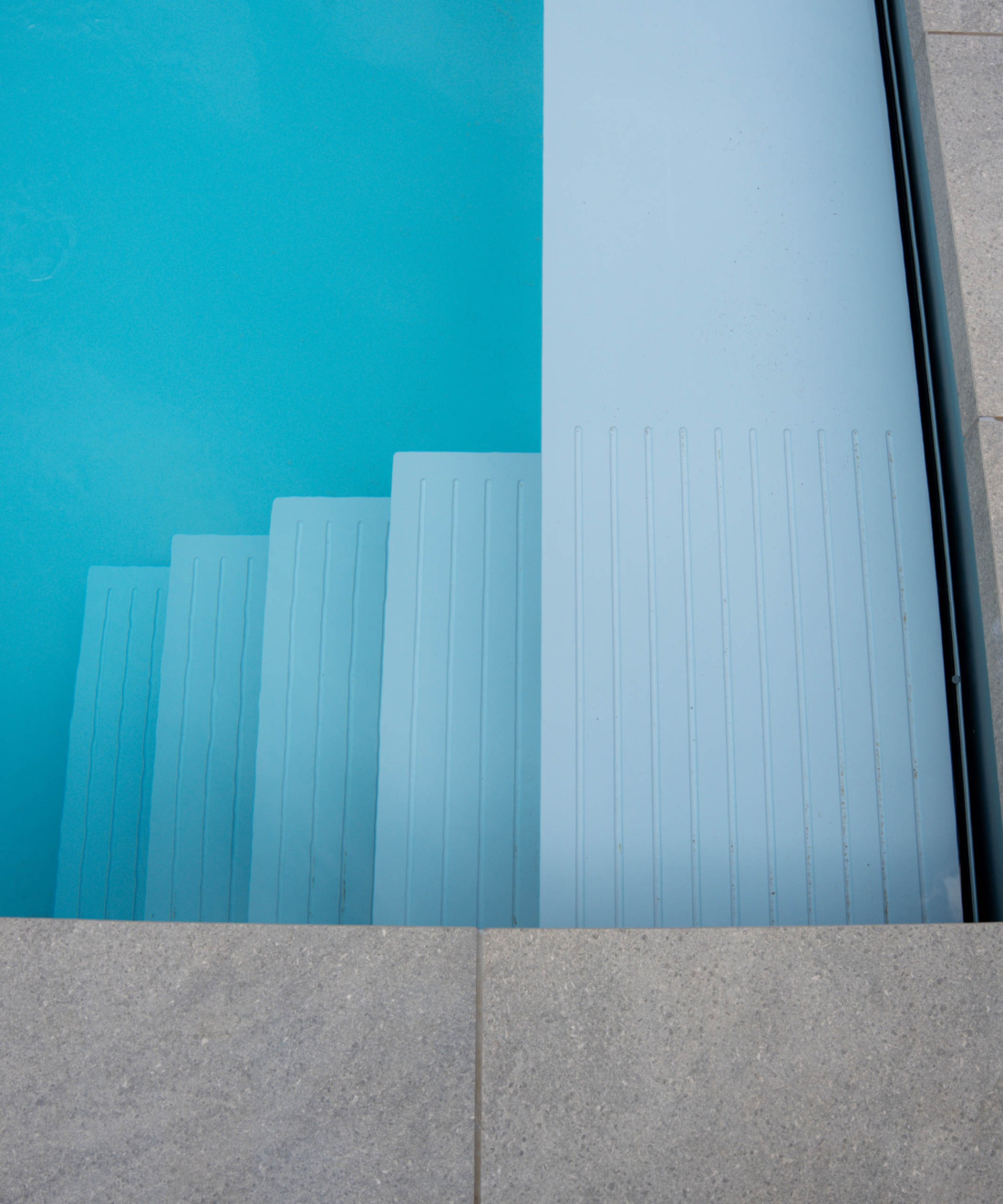 Witte inlooptrap in een HDPE zwembad met helder blauw water