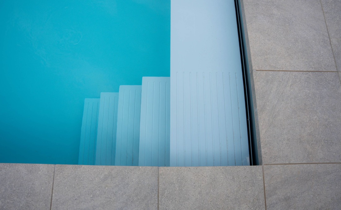 Witte inlooptrap in een HDPE zwembad met helder blauw water