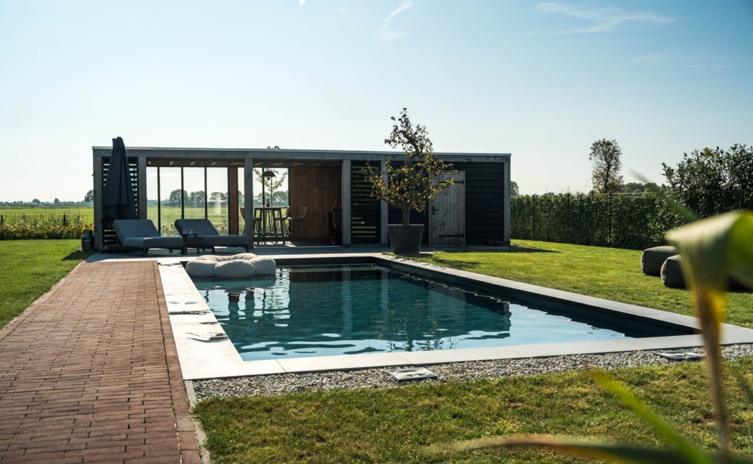 Antraciet zwembad in luxe tuin met overkapping