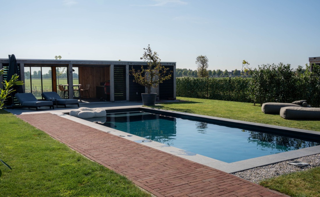 Rechthoeking zwembad met diverse zitzakken, ligbedden en een overdekt gedeelte