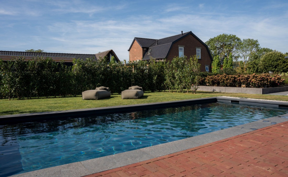 Rechthoekig skimmerzwembad met twee luxe zitzakken van Zaque aan de zijkant