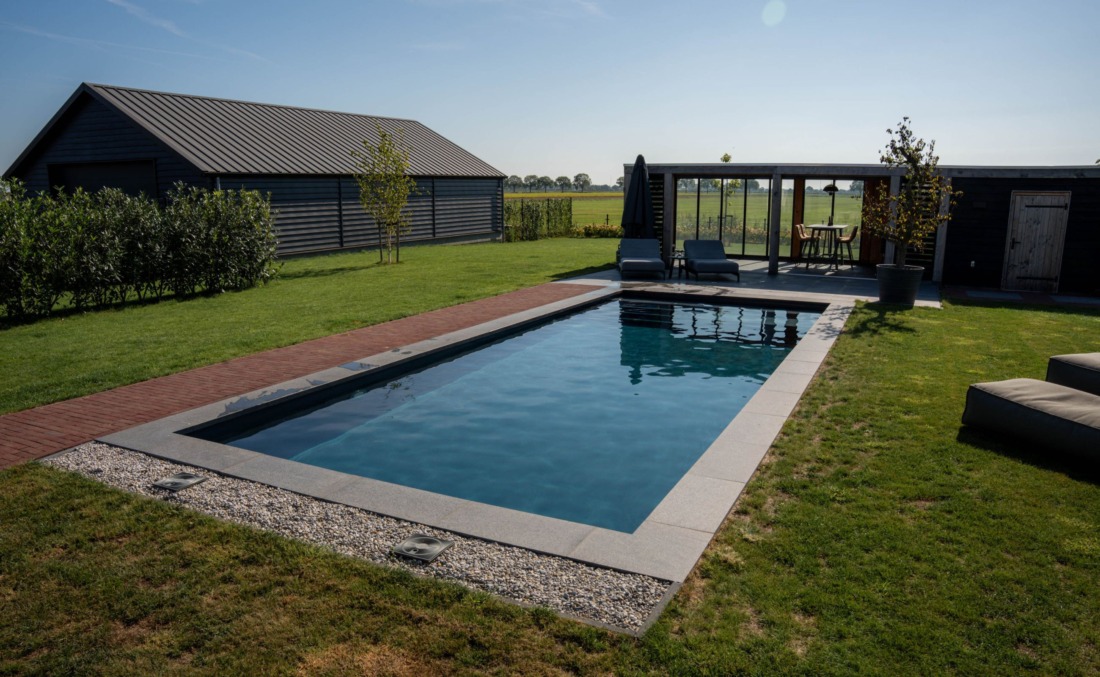 Ruim rechthoekig zwembad in een groene omgeving
