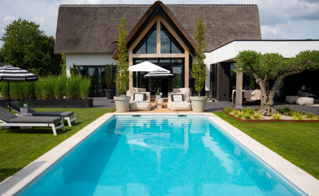 Prachtig wit huis met rieten kap met in de achtertuin in langwerpig HDPE zwembad en diverse ligstoelen