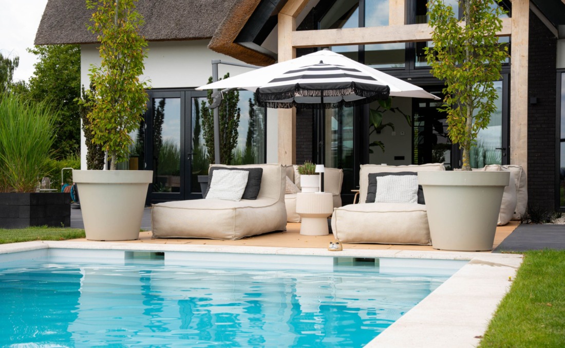 Skimmerzwembad van HDPE met luxe zitzakken van Zaque en twee grote plantenbakken