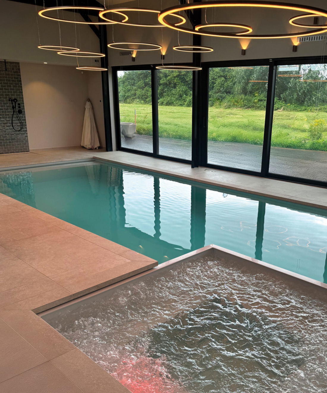 Binnenbad en jaccuzi met helder water in een binnenruimte met luxe ronde decoratieve lampen