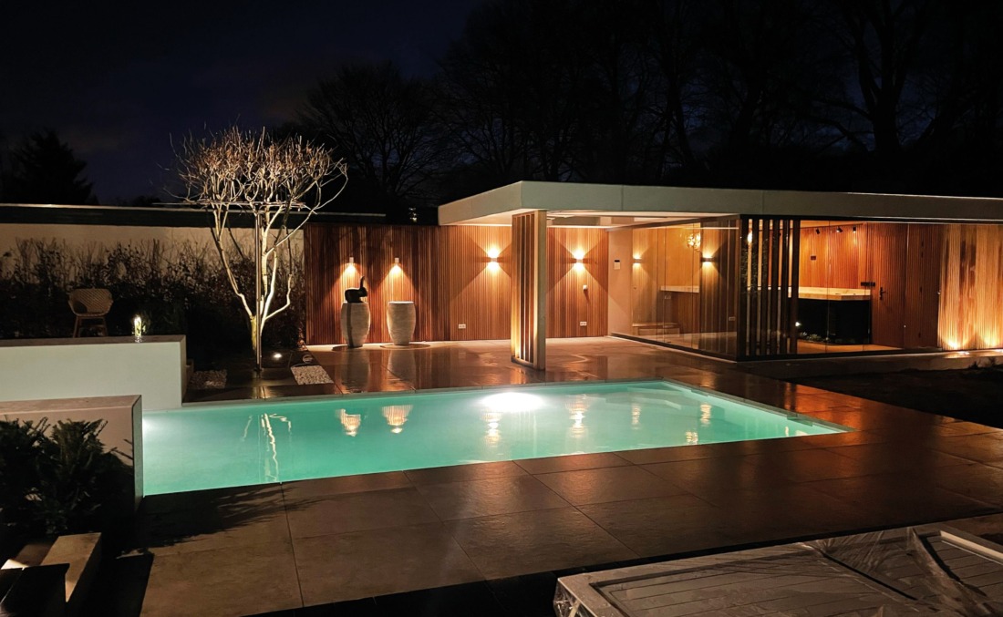 Zwembad in het donker in een luxe tuin met ingebouwde LED-verlichting