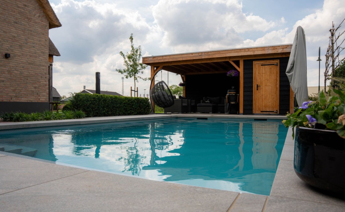 HDPE zwembad met inlooptrap en skimmers bij een houten schuurtje waar ook een hangstoel staat